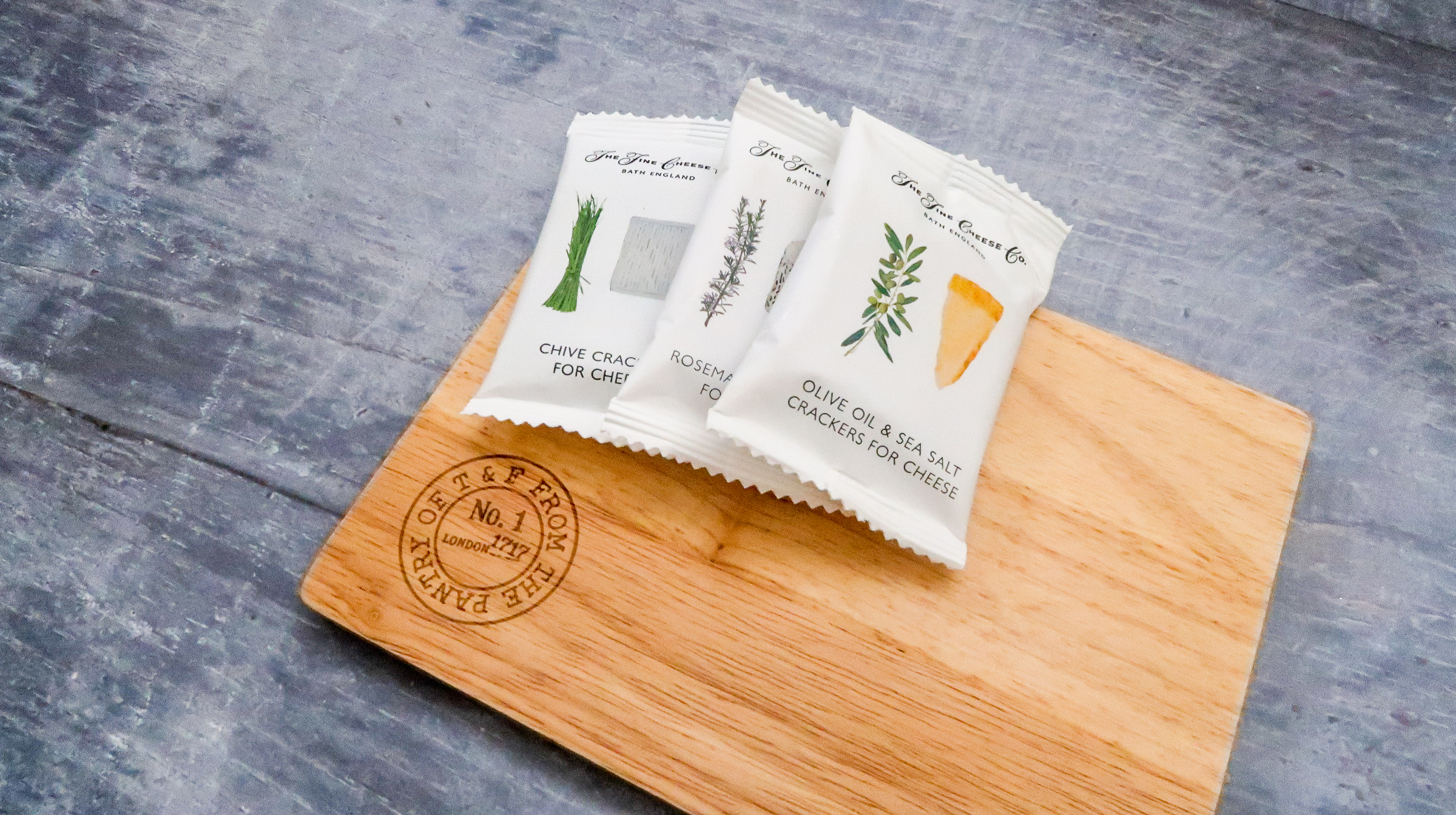 three packets of crackers placed on cheeseboard ready for serving