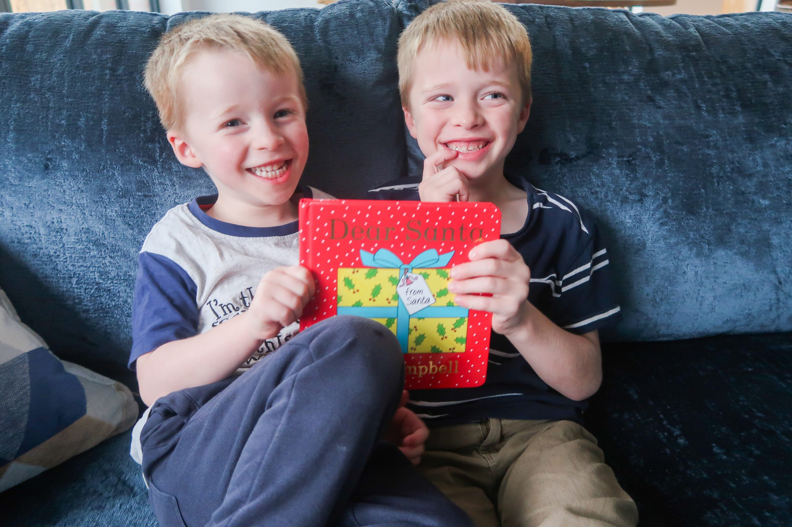 boys on blue sofa holding rod campbell dear santa book